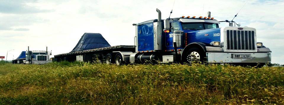 Photo of two BTI trucks parked next to a field.